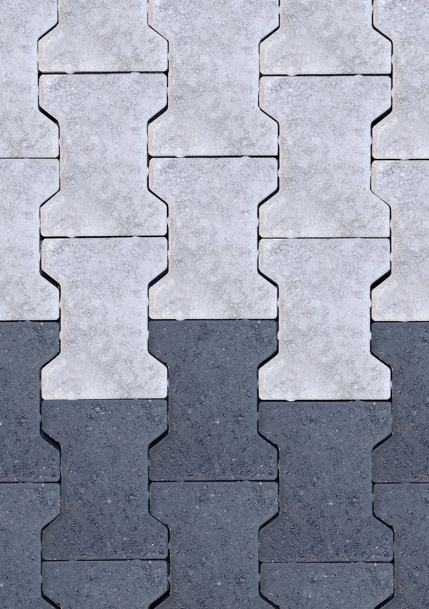 A paver field meeting asphalt where surface water crosses the edge