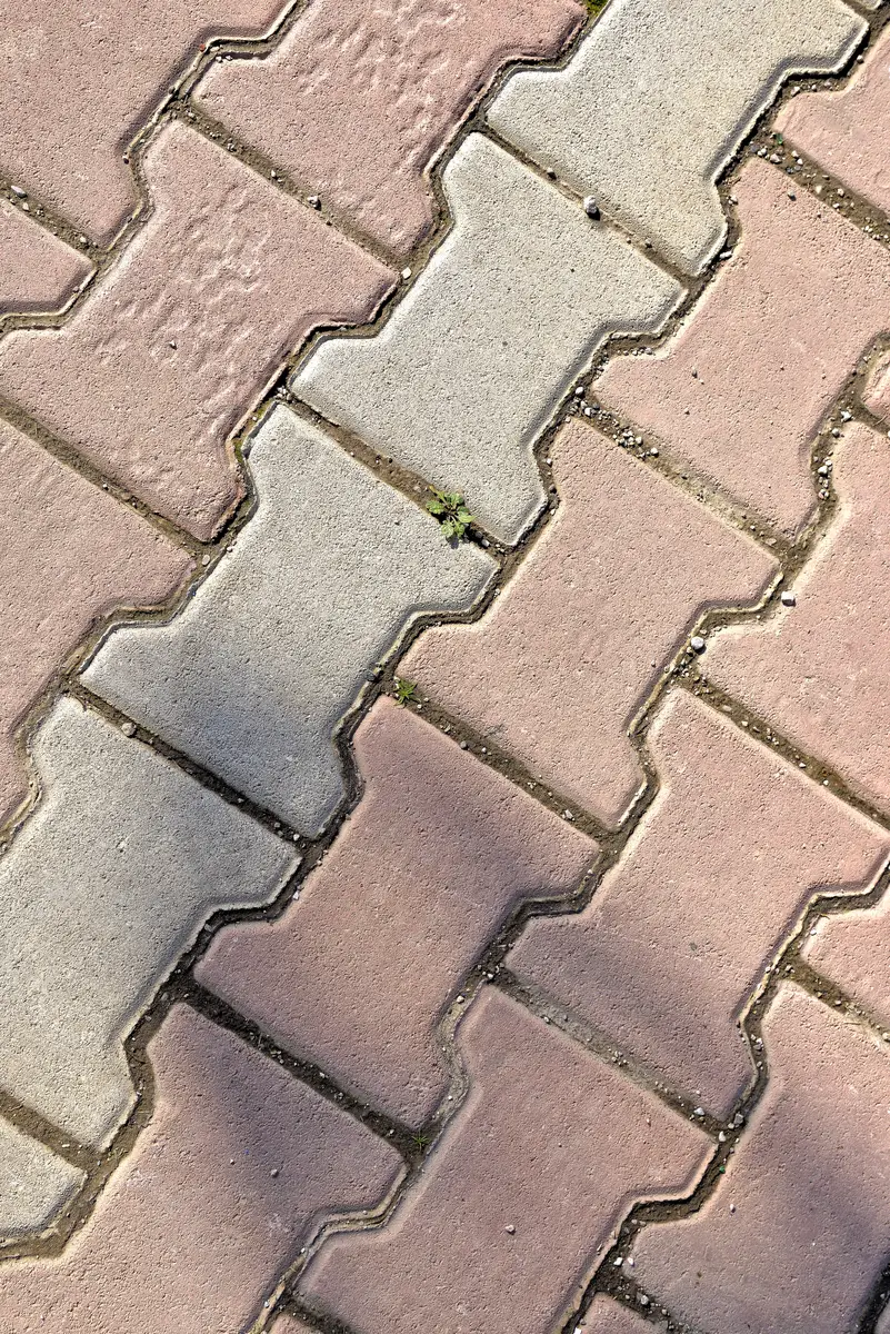 Pink and grey pavers laid together where a line was no longer available